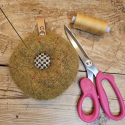 Nlepude med hndbroderet knap