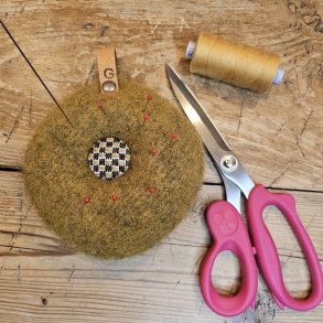 Nlepude med hndbroderet knap