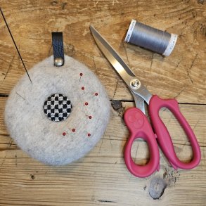 Nlepude med hndbroderet knap